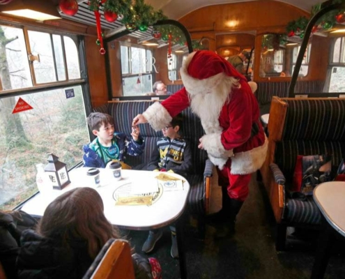 Santa handing out presents on the South Devon Polar Express - one of the Polar Express train ride locations in the UK.