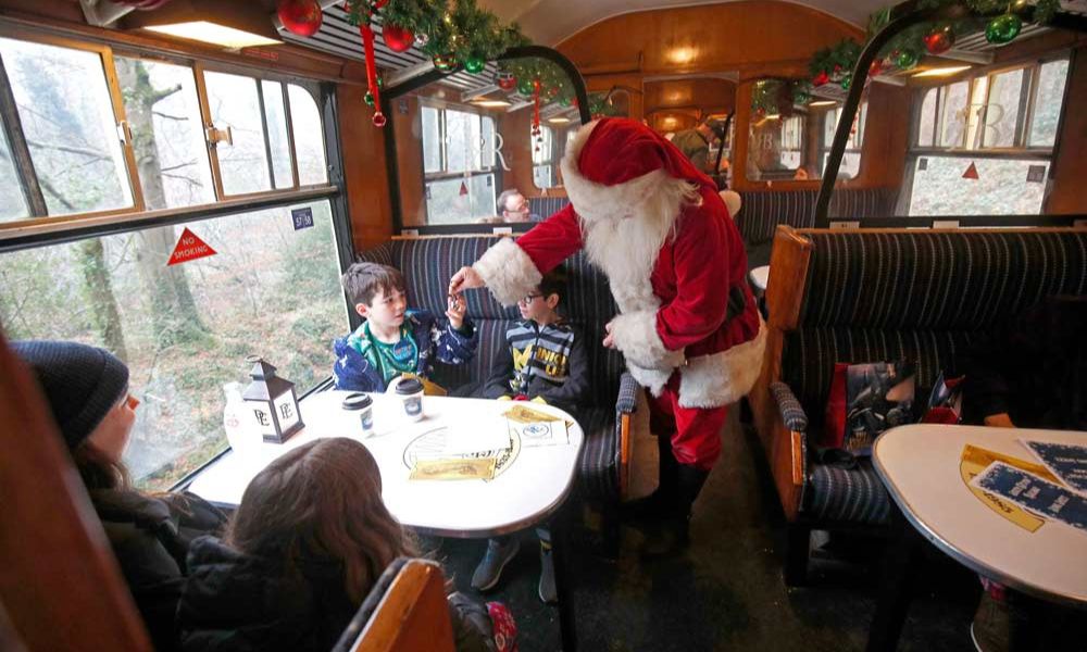 Santa handing out presents on the South Devon Polar Express - one of the Polar Express train ride locations in the UK.