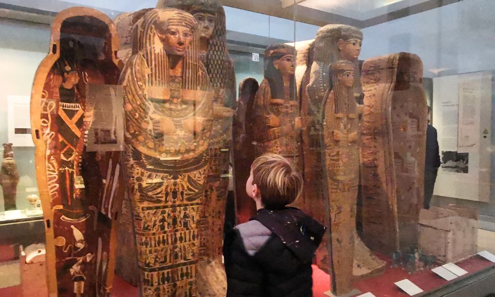 Boy looking at Egyptian mummies in the British Museum in London.
