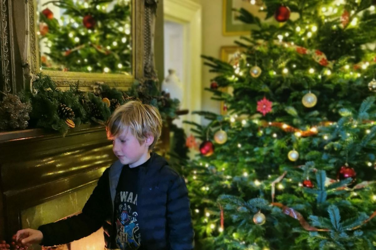 Child looking at Christmas decorations at a hotel on a family Christmas holiday in the UK.
