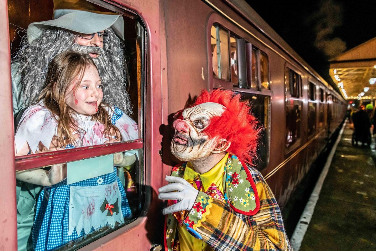 Girl getting scared by a clown on the Halloween train ride at East Lancs Railway.