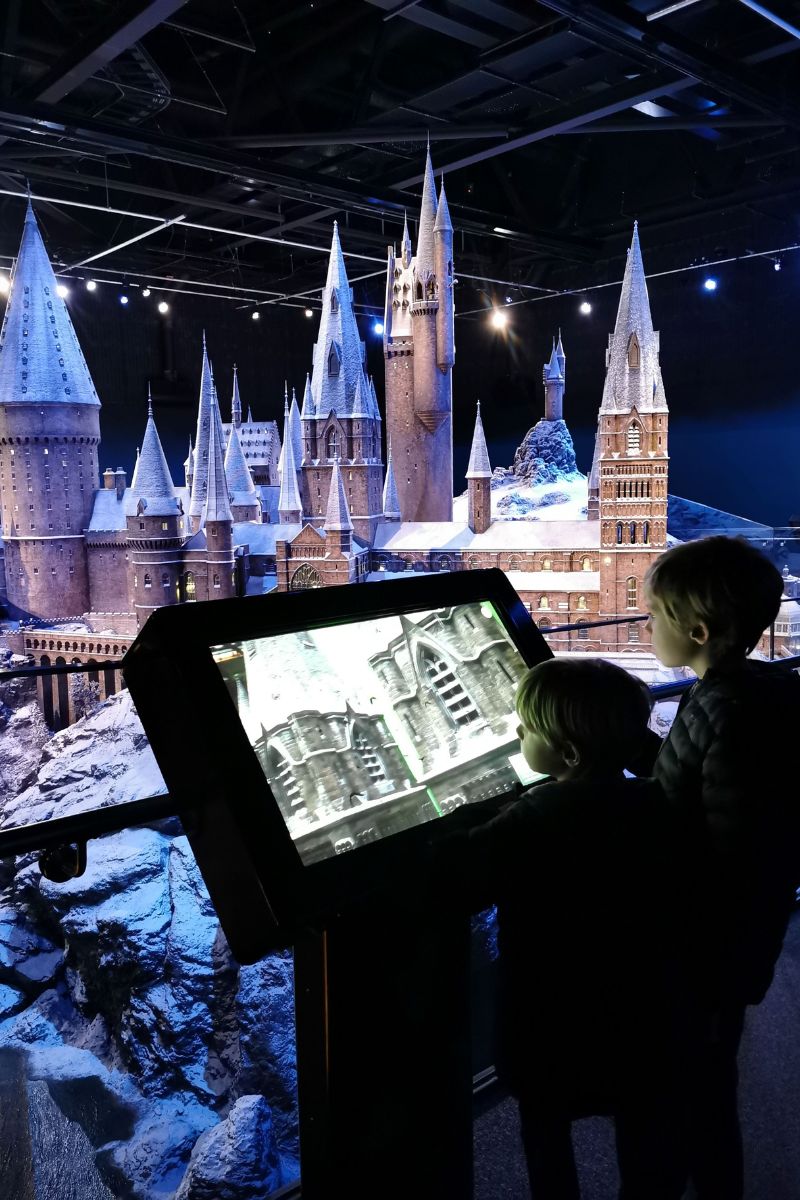 Boys learning about Hogwarts in the Snow at the WB Studio Tour in London - one of the best Harry Potter days out in the UK.