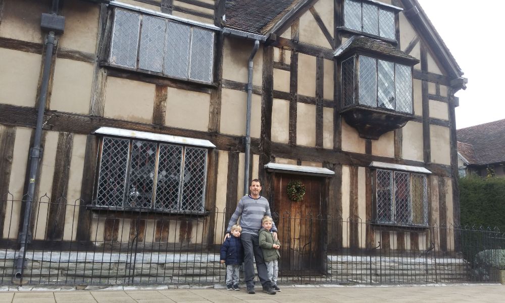 Father and sons standing in front of Shakespeare's Birthplace in Stratford-upon-Avon.