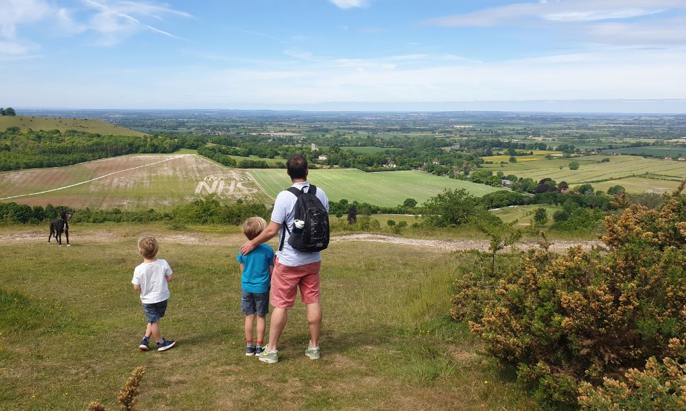 Father and two sons looking at the view from the top of Coombe Hill.