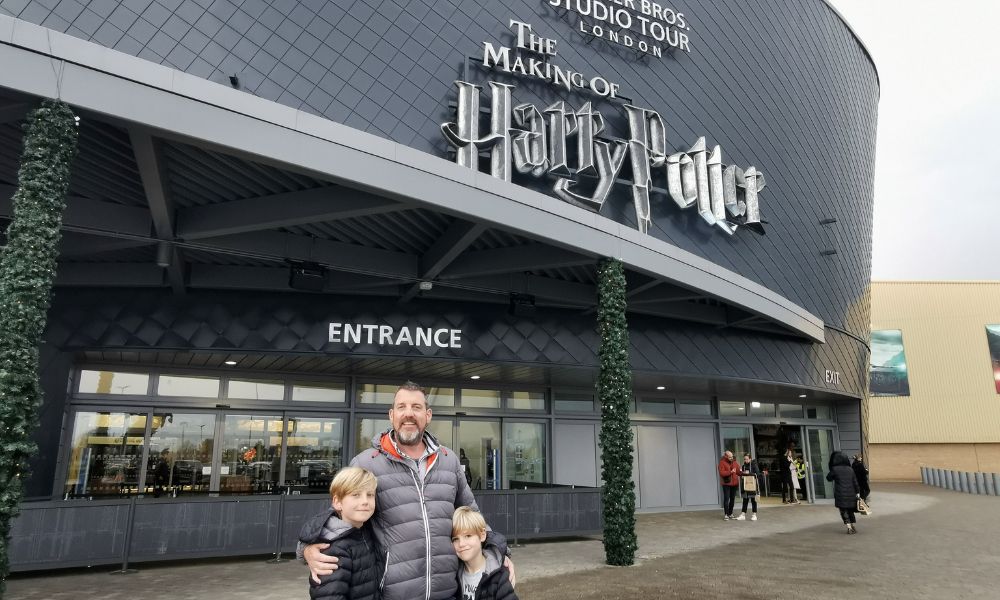 Father and two sons standing outside the Warner Bros Studio Tour.