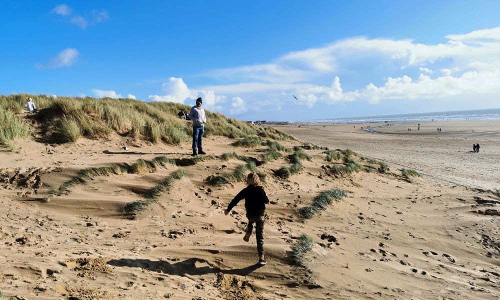 Kids exploring the sand dunes at Camber Sands in Kent.
