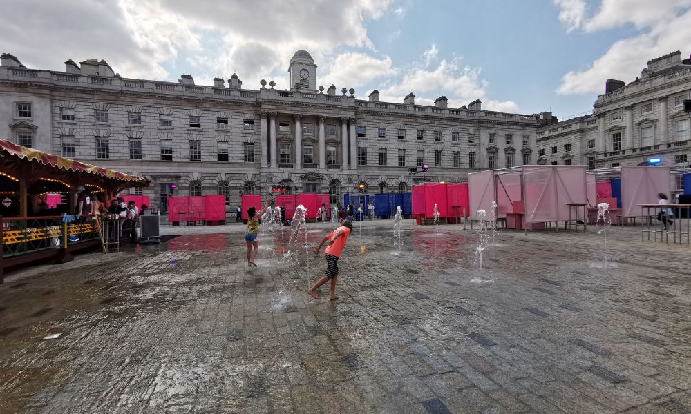 Kids playing in the splash fountains at Somerset House in London - one of our favourite free things to do with kids in London in the summer.