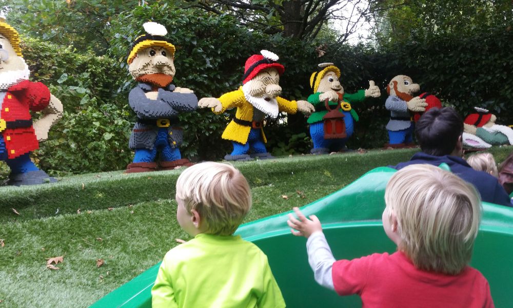 Kids waving at Snow White and the Seven Dwarfs lego figures at Legoland Windsor.