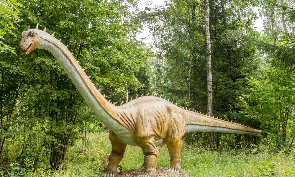 Large model of a dinosaur in a forest setting at one of the best places with dinosaurs in the UK.