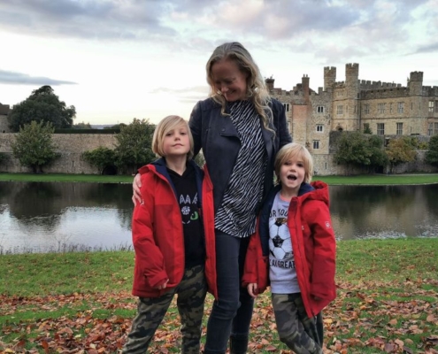 Mother and sons standing in front of Leeds Castle in Kent - a great day trip from London for families.