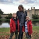 Mother and sons standing in front of Leeds Castle in Kent - a great day trip from London for families.