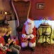 Two little boys in Christmas jumpers talking to Father Christmas at one of the Santa's Grottos in London - one of the best things to do at Christmas in London with kids.