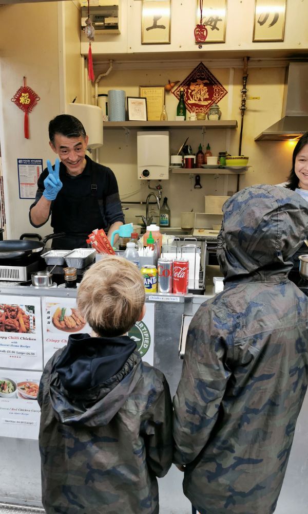 Two kids ordering food at a market stall in Norwich Market.