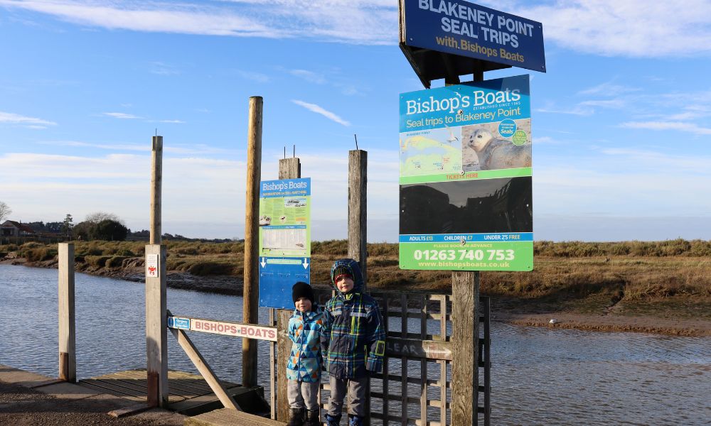 Two kids waiting for a seal boat tour at Blakeney Point on the north Norfolk coast.